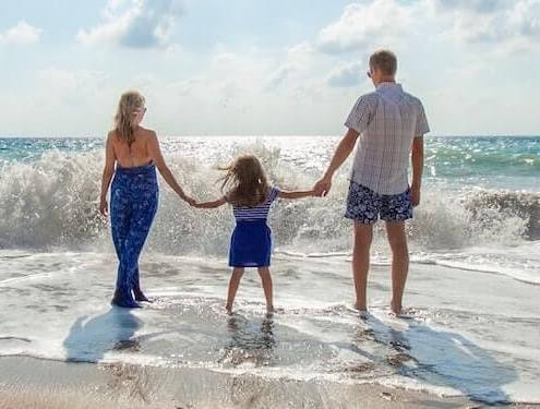 family holding hands at the beach