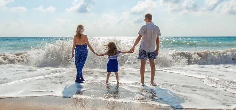 family holding hands at the beach